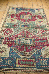 Hand-knotted geometric relief pattern on an antique Kurdish runner in maroon, celadon, and sky blue.