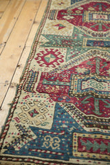 Intricate geometric relief in maroon, ivory, and celadon green hand-knotted pile.