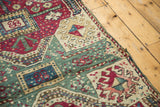 Antique Kurdish runner close-up of intricate geometric relief, time-softened celadon, maroon, and secure side.