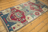 Antique Kurdish runner corner with geometric medallions and secured edge in maroon, ivory, celadon.
