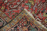 Hand-knotted Mehrivan carpet corner, ivory fringe, cherry red field, and patterned border.