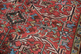 Cherry red field of the vintage Persian Mehrivan rug, showing elongated serrated leaves and low pile.