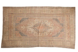 Distressed vintage Oushak rug featuring a faded dusty mauve, ivory, and charcoal medallion.