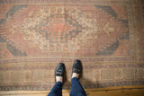 Distressed vintage Oushak rug detail showing dusty mauve, charcoal blue hook motifs.