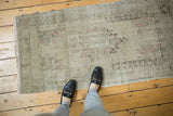 Distressed vintage Oushak rug showing low shorn pile, faded blush, and charcoal details.