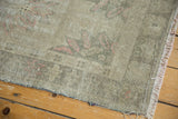 Close-up of the vintage distressed Oushak rug's low shorn pile, foundation showing, and secured fringe.