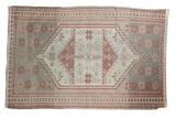 Vintage Distressed Oushak rug: elongated medallion, geometric patterns, abrash, beige, cranberry, slate blue.
