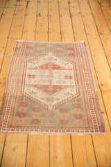Distressed texture, faded floral motifs, and short fringe on a vintage Oushak rug.