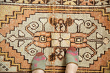 Low pile distressed Oushak rug with lozenge medallion; faint foundation visible. Tangerine, saffron, ivory.