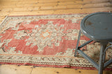 Mid-century Oushak rug with distressed texture, geometric pattern, and softened brick red.