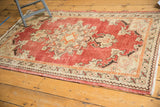 Distressed Oushak rug corner with brick red and antique ivory geometric spandrel and fringe.