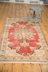 Distressed brick red field and ivory geometric motifs of a vintage Oushak rug.