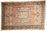 Distressed vintage Oushak rug with dusty blush red field, central medallion, charcoal border.