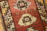 Close-up of distressed Oushak rug showing geometric medallion, barber pole, and abrashed pile.