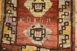Distressed Oushak rug border with barber pole diamonds and stripes in copper, ivory, chestnut brown.
