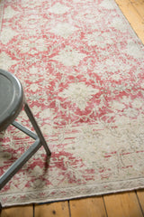 Distressed raspberry red trellis motifs on ivory, showing mostly even wear to knot heads.