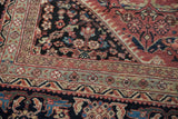 Vintage Mahal carpet detail: intricate cherry red, navy arabesques and floral borders, with low pile.