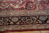 Vintage Mahal carpet's deep black border with blush, navy, and ivory floral motifs, rich red field.