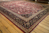 Corner of Vintage Mahal carpet with navy blue border, intricate motifs, and fringe detail.