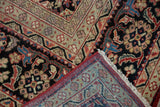 Folded vintage Mahal rug displaying expressive arabesques, cherry red edge, and hand-knotted back.