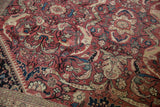 Intricate red, navy, and ivory arabesque and leaf motifs on a vintage Mahal carpet.