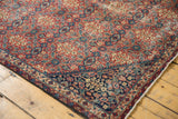 Sivas carpet corner showcases rust field, navy border, inverted henna motifs, with mostly even wear.