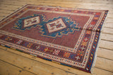Angled view of a vintage Afshar rug highlighting its double diamond medallions and intricate red field.