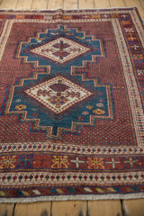 A long perspective view of a vintage Afshar rug's geometric double-diamond medallions.