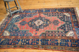 Kurdish Bijar rug with pale brick red field, navy border, and intricate scrolling vinery.