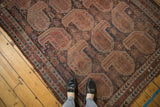 Antique Qashqai rug showcasing oversized geometric paisley boteh motifs in navy, terracotta, and brown.