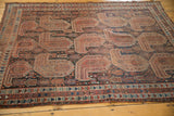 Antique Qashqai rug's oversized geometric paisley boteh motifs with navy, terracotta, and ivory hues.