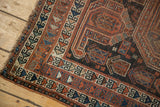 Antique Qashqai rug's corner showcasing tribal geometric border in terracotta and navy.