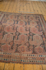 Antique Qashqai rug border: geometric terracotta, navy, ivory patterns, secured fringe.