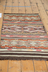Detail of hand-woven Turkish Jijim rug showing embossed geometric bands in orange, wine, brown, and ivory.