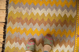 Vintage Jijim rug: gold, tangerine, beige, ivory zigzag chevron pattern, decorative right edge.