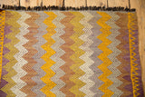Textured hand-knotted zigzag pattern with gold, ivory, bronze tones and dark fringe.
