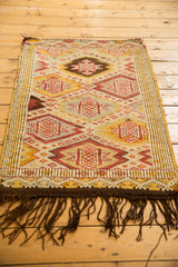 Dark brown fringe with geometric diamond motifs on a vintage Jijim rug.