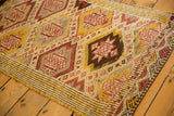 Geometric starburst diamond medallions and striped edge on vintage Jijim rug.
