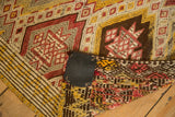 Detail of a hand-knotted vintage Jijim rug folded, revealing foundation weave, geometric patterns, and secured edges.