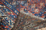 Hand-knotted reverse of a vintage Shiraz rug, revealing fringe and low pile.
