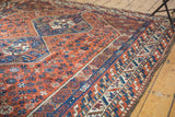 Low pile texture and intricate geometric borders in blue, rust, and ivory.