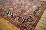 Vintage Mahal carpet: charcoal navy border, brick red field, and stylized floral patterns.