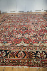 Vintage Mahal rug's brick red field with stylized floral arrangements and charcoal navy border.