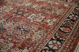 Charcoal navy border and brick red field with stylized floral patterns on vintage Mahal carpet.
