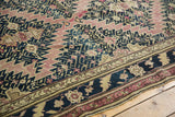 Antique Karabagh carpet with navy, aubergine, and gold floral border, joining a serrated field.
