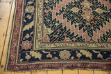 Antique Karabagh carpet corner, revealing serrated field with navy, mauve, and gold floral borders.