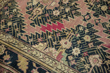 Antique Karabagh carpet detail: sharp serrated aubergine contours, dark navy field, and beige border.