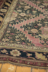 Serrated contour field with aubergine, navy, and pale gold on an antique Karabagh rug.