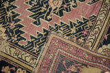 Folded antique Karabagh rug showing sharp serrated pattern, pile wear, and woven reverse.