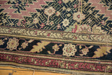 Antique Karabagh carpet border featuring navy blue, aubergine, and pale gold stylized floral motifs.